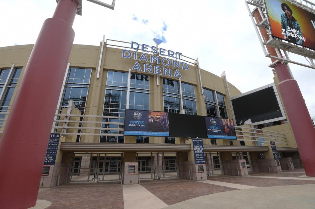 Exterior view of Desert Diamond Arena featuring large signs and entry points, with digital billboards advertising events.